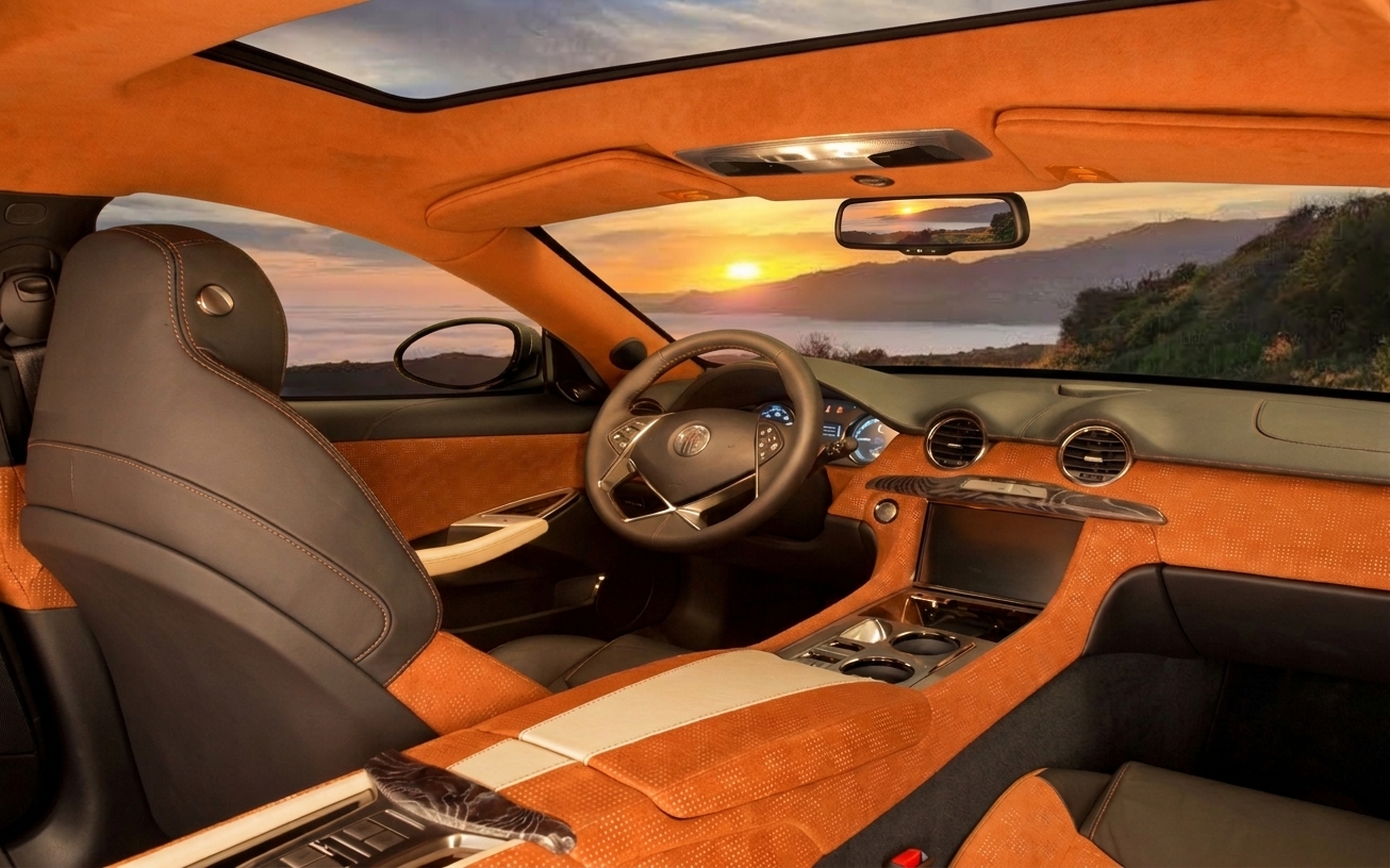 Fisker Surf cockpit in orange leather with dual displays, looking out to a coastal sunrise